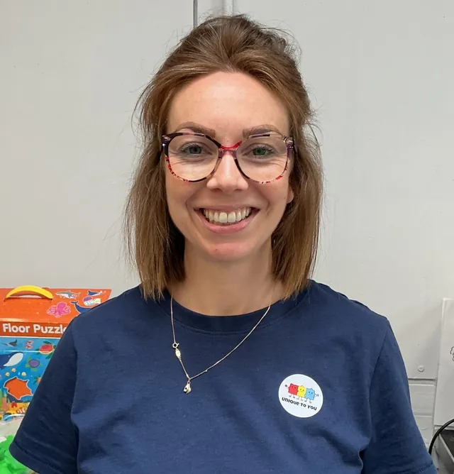 Lizzie, founder of Unique to You, smiling, wearing a Unique to You badge